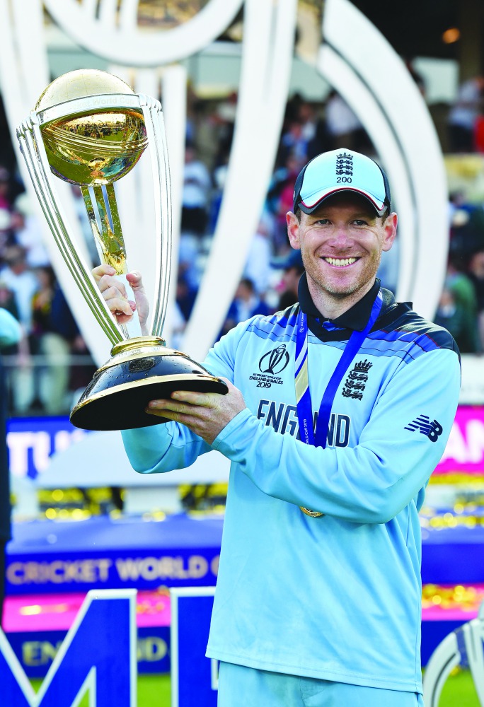 England's captain Eoin Morgan poses with the World Cup trophy as England's players celebrate their win after the 2019 Cricket World Cup final between England and New Zealand at Lord's Cricket Ground in London on July 14, 2019.  AFP / Glyn Kirk 