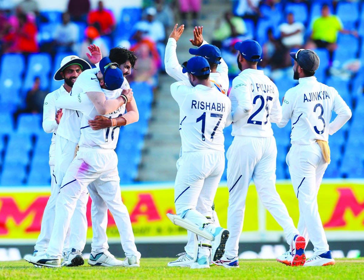 Ishant Sharma (L) and Virat Kohli (2L) of India celebrates the dismissal of Kemar Roach of West Indies during day 2 of the 1st Test between West Indies and India at Vivian Richards Cricket Stadium in North Sound, Antigua and Barbuda, on August 23, 2019. A