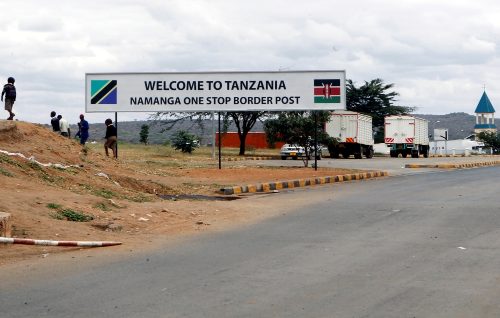 Children walk past a signage at the border crossing point between Kenya and Tanzania in Namanga, Tanzania July 19, 2019. Picture taken July 19, 2019. REUTERS/Njeri Mwangi