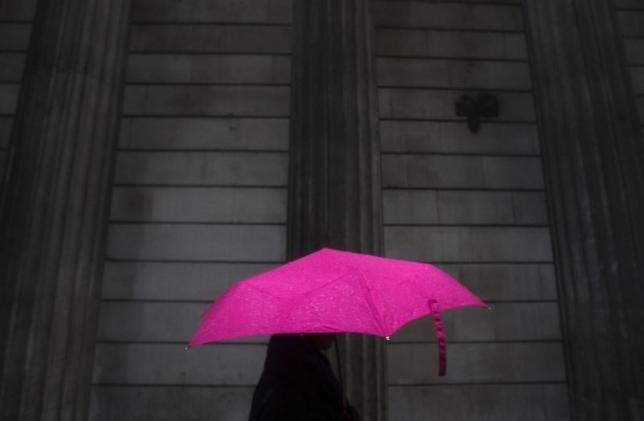 A woman carries an umbrella during a rain shower as she walks past the Bank of England in London, November 30, 2009. Reuters / Andrew Winning