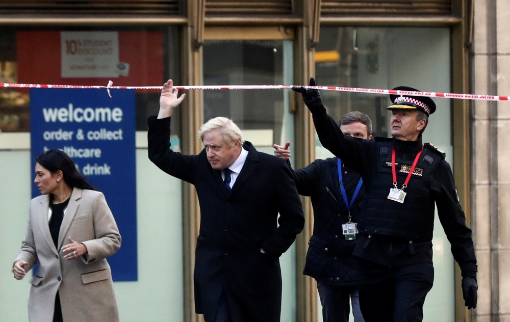 Britain's Prime Minister Boris Johnson, (C), Britain's Home Secretary Priti Patel, (L) and Commissioner of the City of London Police, Ian Dyson (R) arrive at the scene of a stabbing, on London Bridge in the City of London on November 30, 2019. AFP / Simon