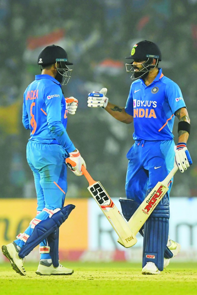India's Ravindra Jadeja (L) clebrates after scoring a boundary with captain Virat Kohli during the third one day international cricket match of a three-match series between India and West Indies at the Barabati Stadium in Cuttack on December 22, 2019. AFP