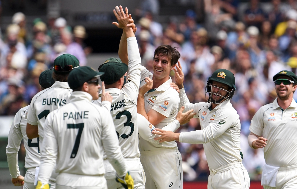 Australia's bowler Pat Cummins (C) celebrates with teammates after dismissing New Zealand batsman Henry Nicholls on the third day of the second cricket Test match against Australia at the MCG in Melbourne on December 28, 2019./ AFP / WILLIAM WEST / 
