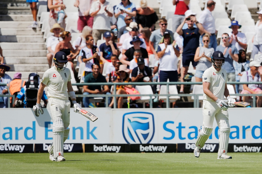 England's Dom Sibley (L) and England's Zak Crawley (R) walks on the field to bat during the first day of the second Test cricket match between South Africa and England at the Newlands stadium in Cape Town on January 3, 2020. (AFP / MARCO LONGARI)