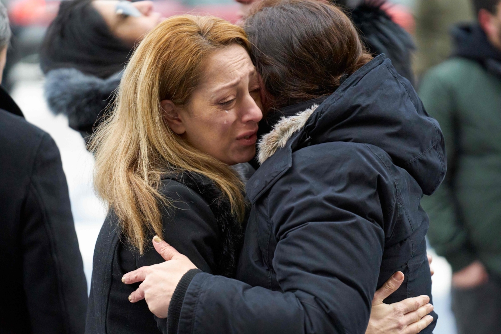 A woman sheds a tear during a memorial service at the University of Toronto in Toronto, Ontario on January 12, 2020 for the victims of Ukrainian Airlines flight 752 which was shot down over Iran this past week. AFP / Geoff Robins
