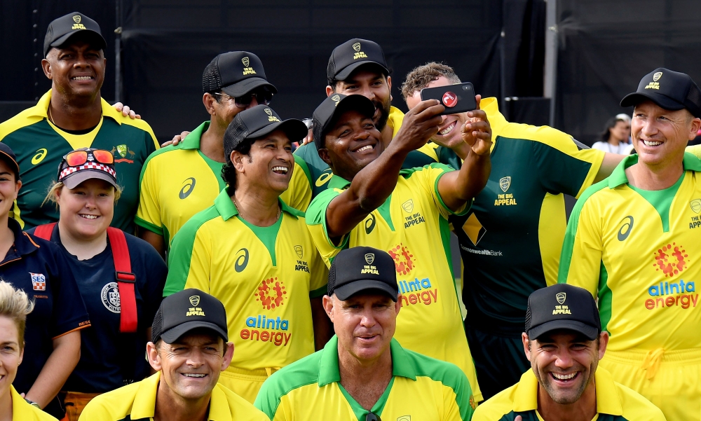 Former Indian player Sachin Tendulkar (centre L) and West Indies player Brian Lara (centre-R) pose for a selfie after a celebrity cricket match to raise funds for people affected by the Australian bushfires, in Melbourne on February 9, 2020. / AFP / WILLI