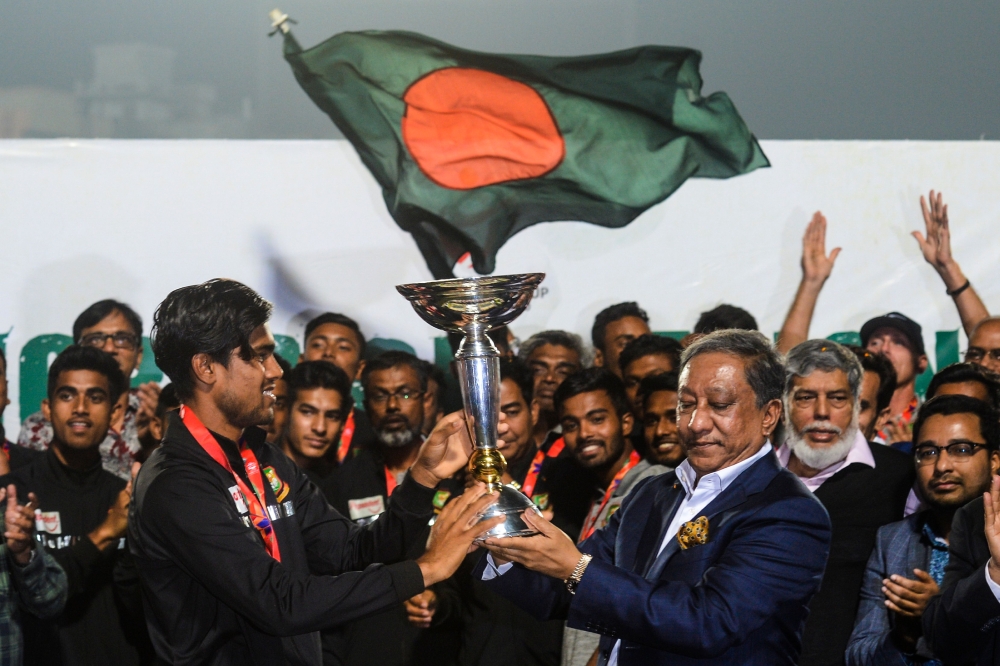 Bangladesh's Cricket Board President Nazmul Hasan Papon (R) and Bangladesh's Under-19 cricket team captain Akbar Ali (L) hold the International Cricket Council (ICC) Under-19 World Cup trophy during a reception ceremony in the Sher-e-Bangla National Crick