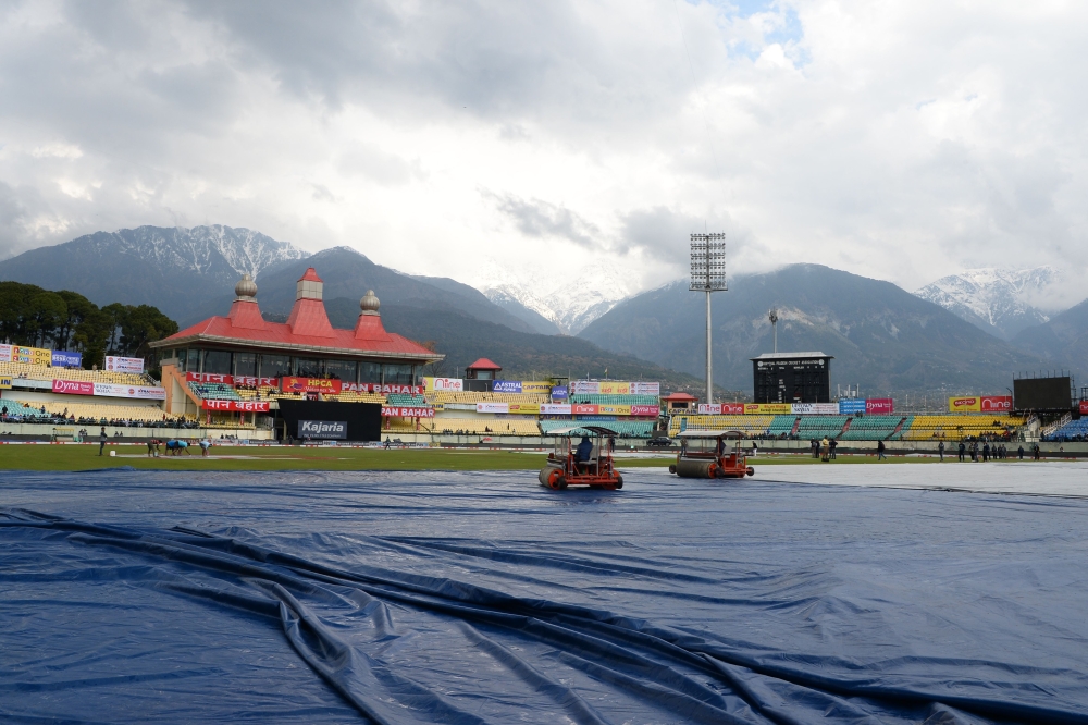 Ground staff work on the pitch ahead of the start of first one day international (ODI) cricket match of a three match series between India and South Africa, at the Himachal Pradesh Cricket Association Stadium in Dharamsala on March 12, 2020. 
/ AFP / Saj