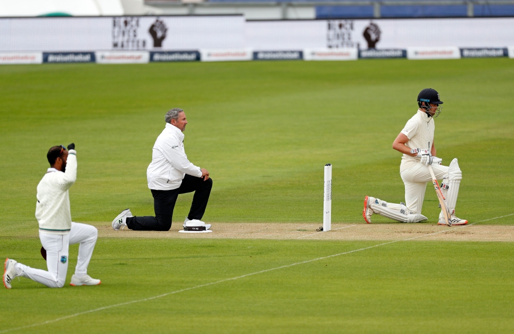 England's Dom Sibley (R) 'takes a knee' in support of the Black Lives Matter movement ahead of on the first day of the first Test cricket match between England and the West Indies at the Ageas Bowl in Southampton, southwest England on July 8, 2020. / AFP 