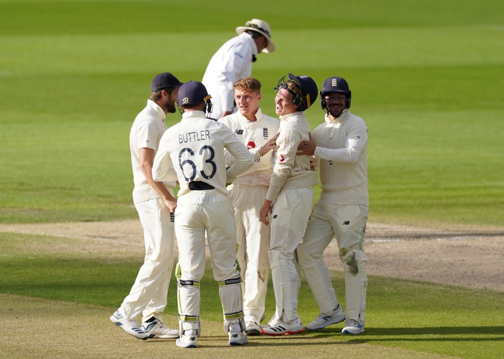 England's Jos Buttler celebrates with teammates after winning the test, as play resumes behind closed doors following the outbreak of the coronavirus disease (COVID-19) Jon Super/Pool via REUTERS