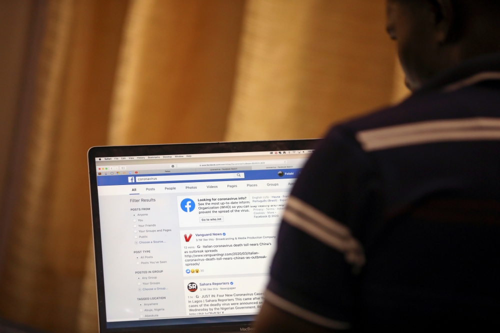 FILE PHOTO: FILE PHOTO: A man opens the Facebook page on his computer to fact check coronavirus disease (COVID-19) information, in Abuja, Nigeria March 19, 2020. REUTERS/Afolabi Sotunde -/File Photo
