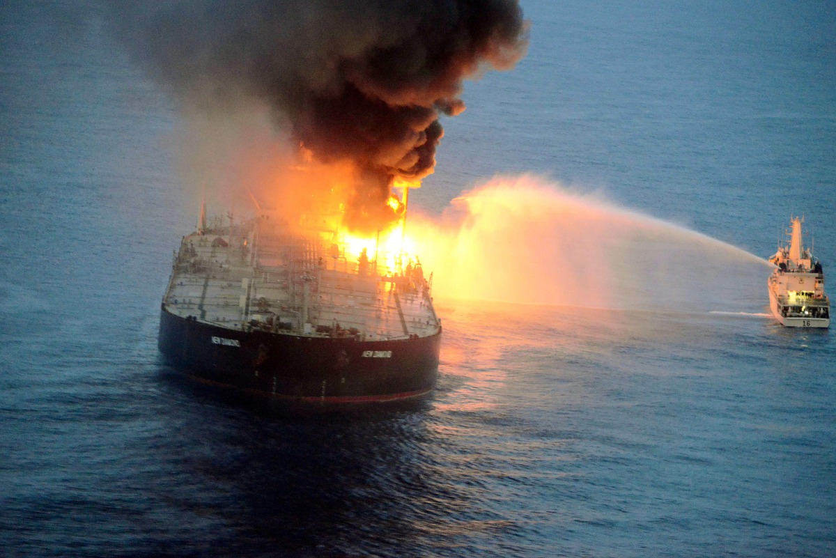 TOPSHOT - This handout photograph taken on September 4, 2020, and released by Sri Lanka's Air Force, shows an Indian coast guard ship (R) battling to extinguish the fire from the Panamanian-registered crude oil tanker New Diamond, some 60 km off Sri Lanka