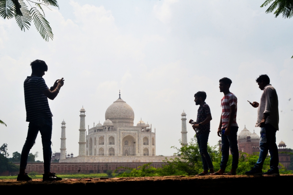 People take pictures with their mobile phones near the Taj Mahal in Agra on September 8, 2020. AFP / Pawan Sharma 