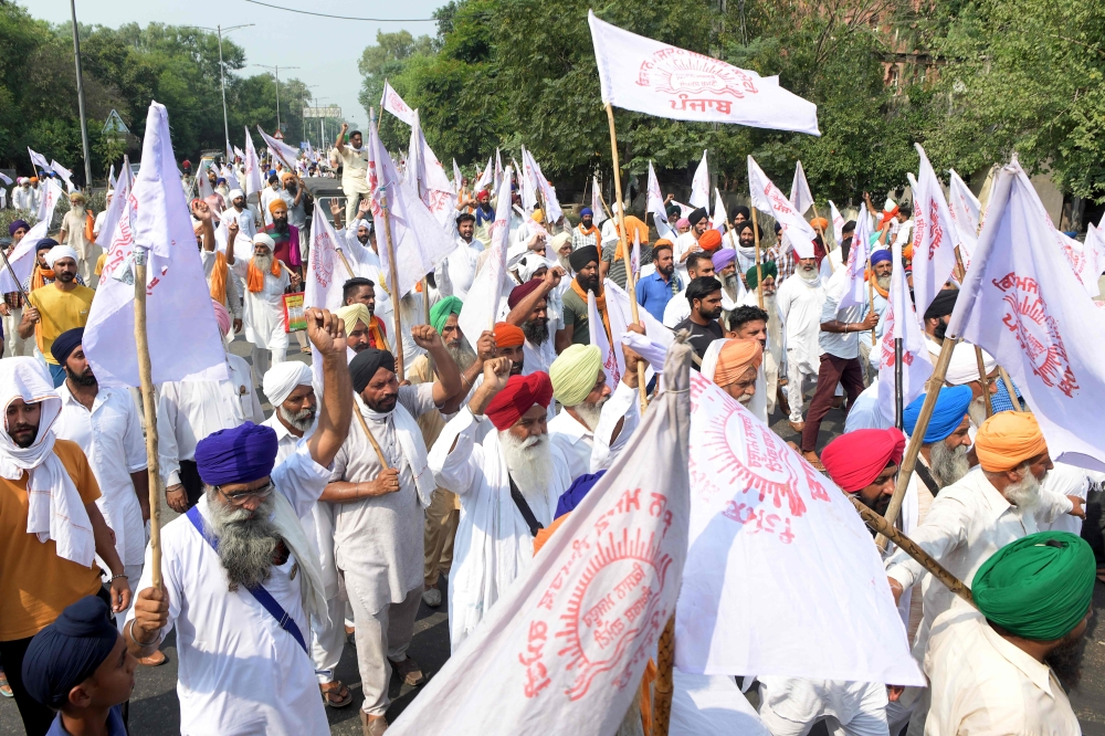 Farmers shout slogans as they march to burn an effigy of India's Prime Minister Narendra Modi and Union Agriculture Minister Narendra Singh Tomar, following the passing of agriculture bills in the Lok Sabha (lower house) of representatives, on the outskir