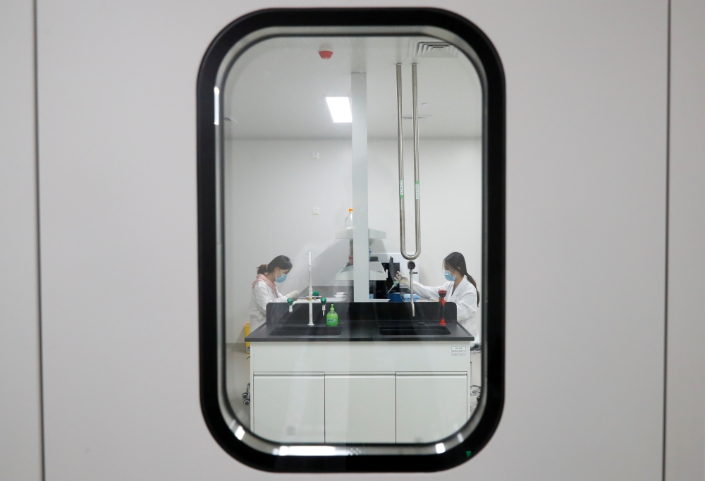 Women work in a laboratory of Chinese vaccine maker Sinovac Biotech, developing an experimental coronavirus disease (COVID-19) vaccine, during a government-organized media tour in Beijing, China, September 24, 2020. REUTERS/Thomas Peter/File Photo/File Ph