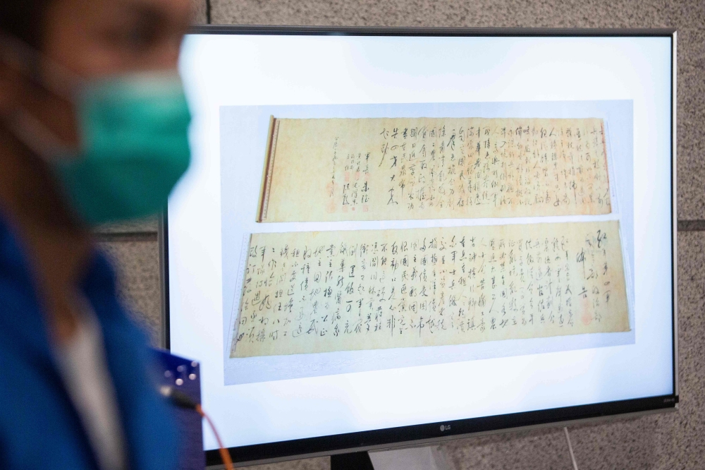 Police show a picture of a calligraphy scroll written by Mao Zedong worth about 300 million USD, that had been recovered but found chopped in half following a robbery that included antique stamps and revolutionary items from mainland China worth an estima