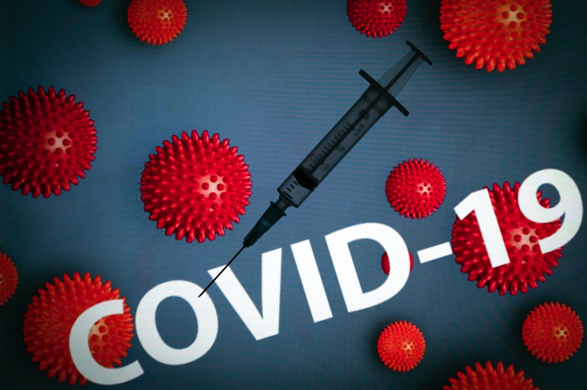 This photograph taken on October 7, 2020 shows a syringe on an illustration representing Covid-19 (novel coronavirus), in Toulouse, southwestern France. / AFP / Lionel BONAVENTURE
