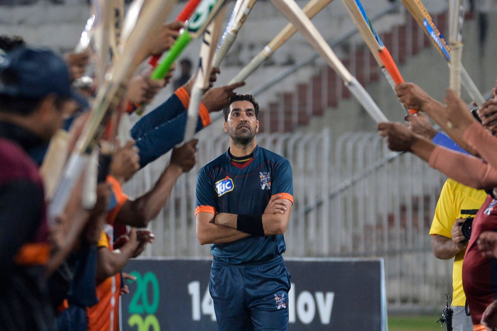 In this picture taken on October 16, 2020 teammates and opponents give a guard of honour to Pakistani cricketer Umar Gul (C) during the National T20 Cup in Rawalpindi. AFP / Aamir Qureshi 