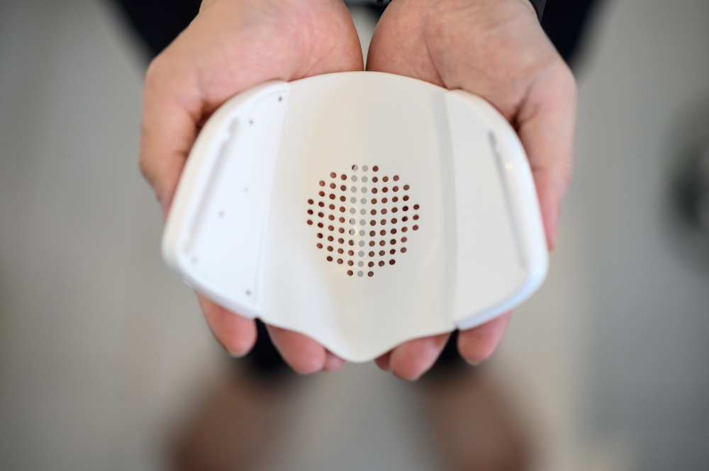 This picture taken on September 29, 2020 shows Donut Robotics chief executive Taisuke Ono showing the interior of the smart mask 