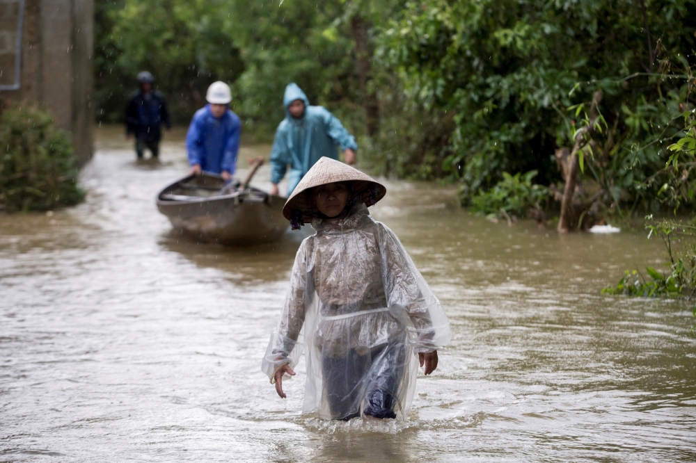 Residents wade along a flooded road at a village in Quang Tri province, Vietnam October 20, 2020. Picture taken October 20, 2020. Yen Duong/International Federation of the Red Cross (IFRC)/Handout via REUTERS
