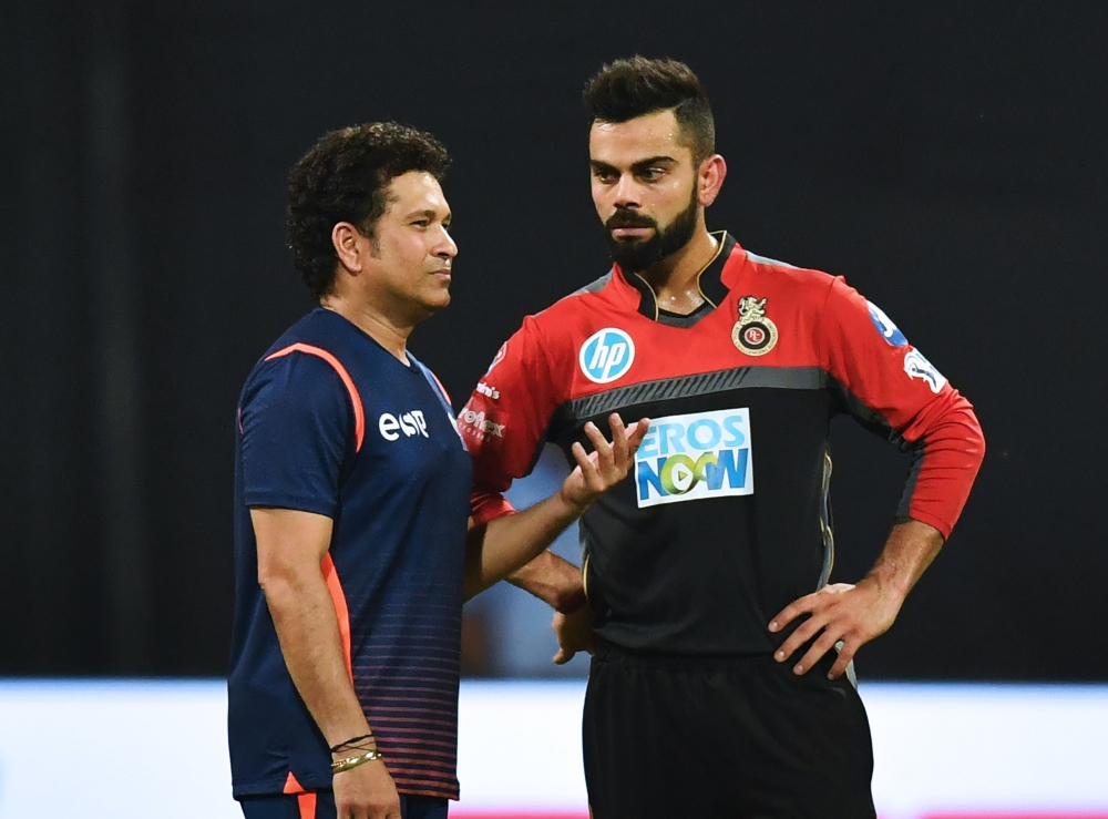 Royal Challengers Bangalore captain Virat Kohli (R) speaks with Mumbai Indians team mentor Sachin Tendulkar before the start of the 2018 Indian Premier League (IPL) Twenty20 cricket match at the Wankhede stadium in Mumbai. Gettyout / AFP / Punit Paranjpe 