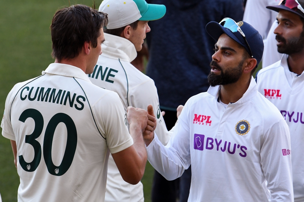 India's Virat Kohli (R) congratulates Australia's Pat Cummins (L) on the third day of the first cricket Test match between Australia and India in Adelaide on December 19, 2020. AFP / William West  