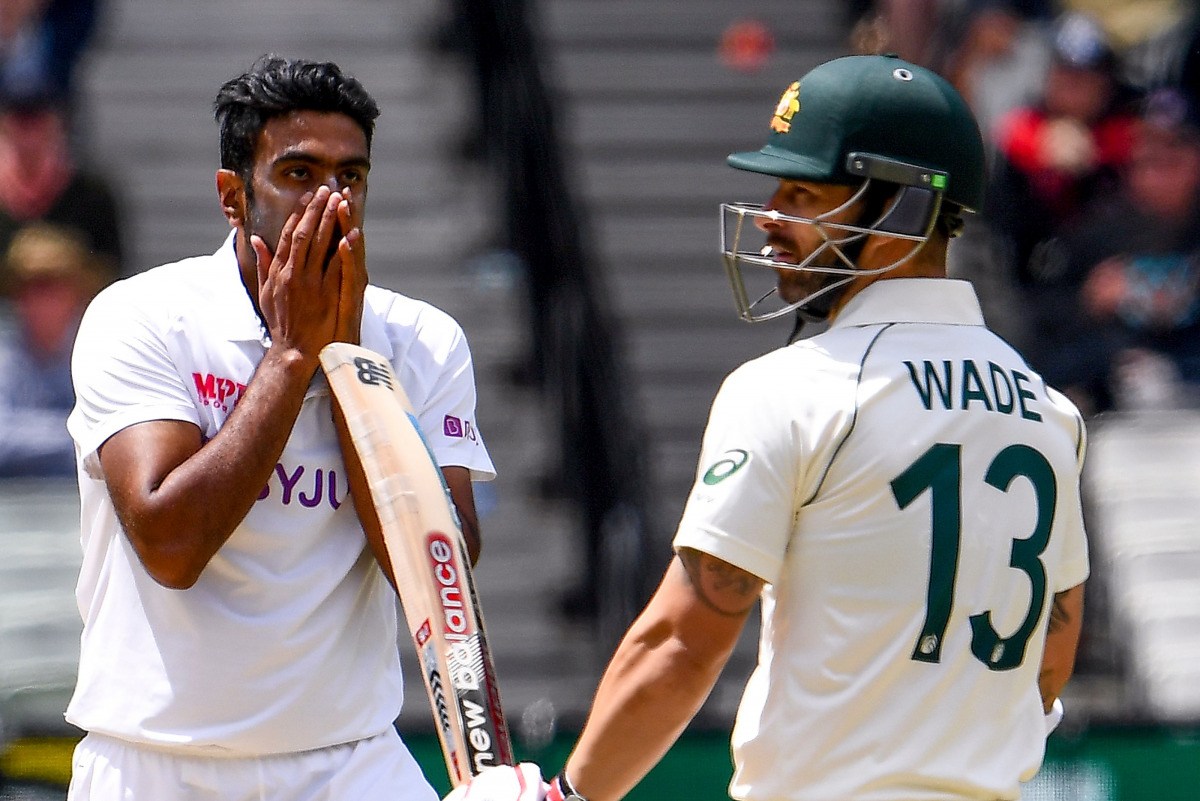 TOPSHOT - India's Ravi Ashwin (L) reacts after nearly dismissing Australia's Matthew Wade (R) on the third day of the second cricket Test match between Australia and India played at the MCG in Melbourne on December 28, 2020. / AFP / WILLIAM WEST /