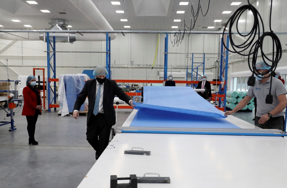 Britain's Prime Minister Boris Johnson, wearing a face mask to prevent the spread of the coronavirus disease (COVID-19), visits a PPE manufacturing facility, in Seaton Delaval, Britain, February 13, 2021. Scott Heppell/Pool via REUTERS