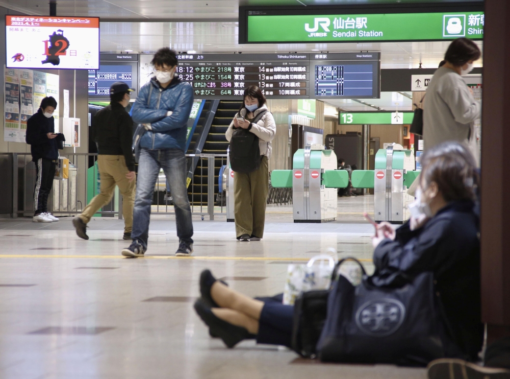 People sit on the floor at a station as train services are suspended following an earthquake in Sendai, Miyagi prefecture, Japan in this photo taken by Kyodo on March 20, 2021.  Kyodo