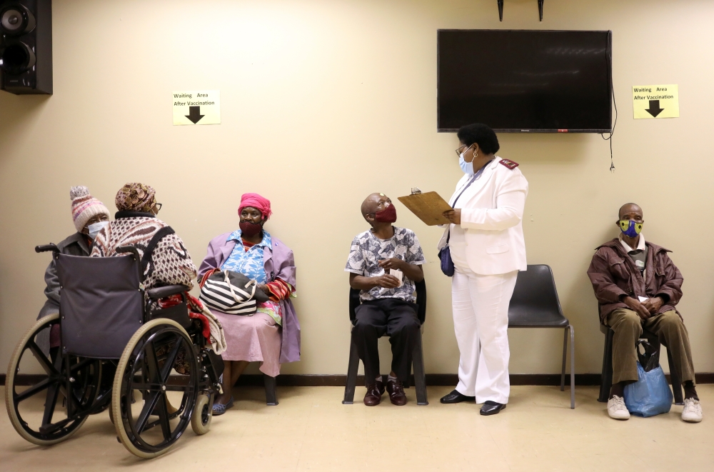A nurse talks to a man following his vaccination, as South Africa rolls out the coronavirus disease (COVID-19) vaccines to the elderly at the Munsieville Care for the Aged Centre outside Johannesburg, South Africa May 17, 2021. REUTERS/Siphiwe Sibeko