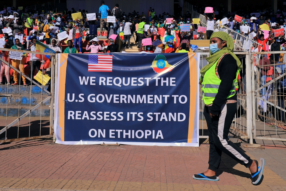 A pro-government demonstrator walks past a banner as they attend a rally to protest against the U.S. action over alleged human rights abuses during the conflict in the Tigray region, in Addis Ababa, Ethiopia May 30, 2021. REUTERS/Tiksa Negeri