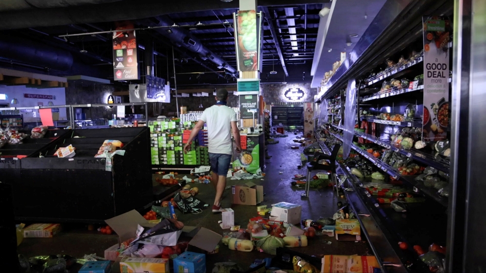 A self-armed local looks for looters inside a supermarket following protests that have widened into looting, in Durban, South Africa July 13, 2021, in this screen grab taken from a video. Courtesy Kierran Allen/via REUTERS 
