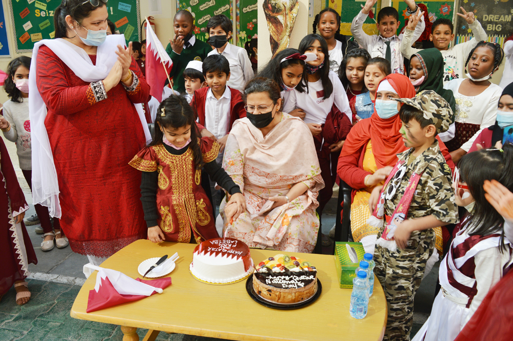 PISQ Principal Nargis Raza Otho and other teachers and students cutting a cake to mark the day.