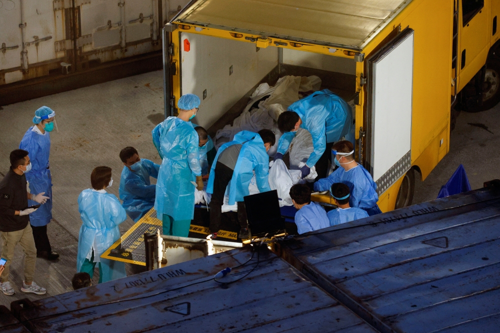 Corpses are moved to a refrigerated container outside a funeral home, as mortuaries run out of space amid the coronavirus disease (COVID-19) outbreak in Hong Kong, China, March 5, 2022. REUTERS/Tyrone Siu