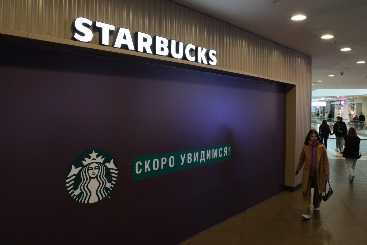 A woman walks past a closed Starbucks cafe in central Saint Petersburg, Russia May 23, 2022. REUTERS/Anton Vaganov

