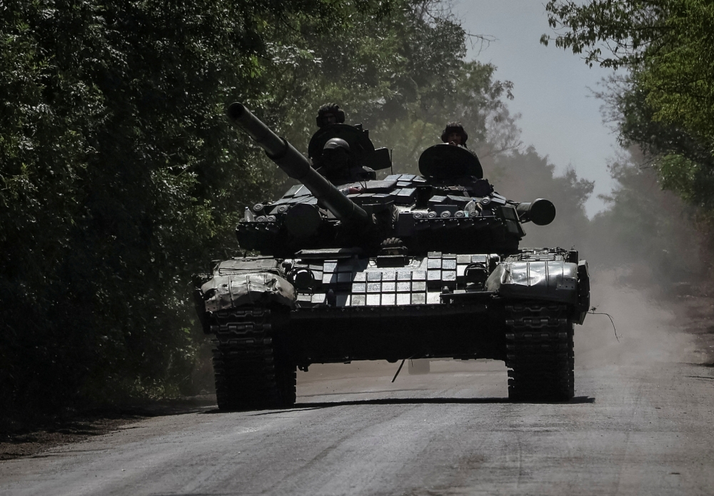 Ukrainian servicemen ride a tank near a frontline, amid Russia's attack on Ukraine, in Donbas region, Ukraine July 13, 2022. REUTERS/Gleb Garanich/File Photo