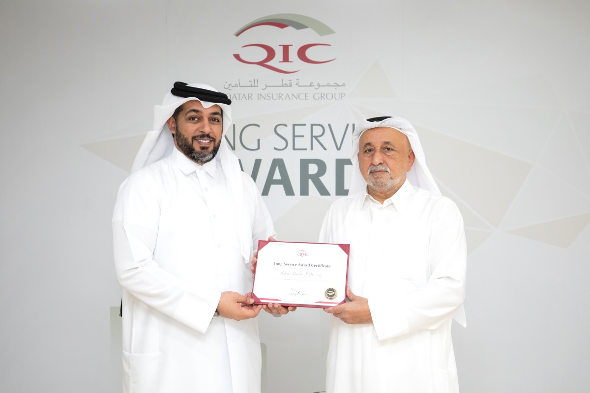Khalifa Abdulla Turki Al Subaey (right), Chairman & Managing Director of QIC Group, hands over a long service award to Salem Al Mannai, QIC Group CEO, recently.  