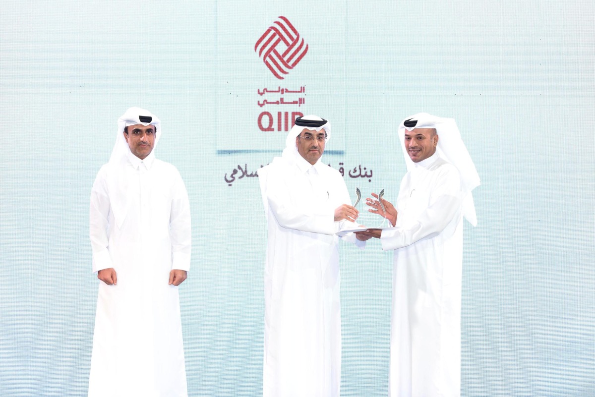 Minister of Labour H E Dr. Ali bin Smaikh Al Marri presents the award to Ali Hamad Al Musaifri, Head of the Human Resources and Administrative Affairs Sector at QIIB, during the ceremony in Doha, recently. 