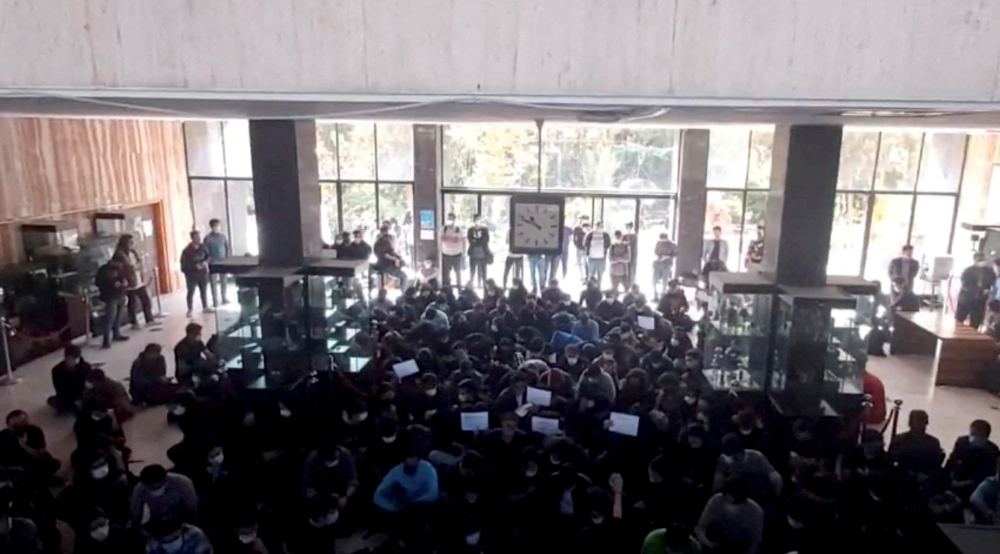 Protesters chant at a vigil for Mahsa Amini, the woman who died in police custody last month, at the entrance hall of the Khajeh Nasir Toosi University of Technology in Tehran, Iran, in this screengrab from social media video released on October 26, 2022 and obtained by REUTERS