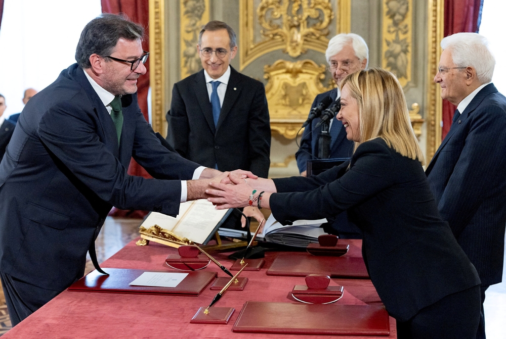 Italy's new Economy Minister Giancarlo Giorgetti shakes hands with Italy's Prime Minister Giorgia Meloni during the swearing-in ceremony at the Quirinale Presidential Palace, in Rome, Italy, October 22, 2022. (Italian Presidency/Handout via REUTERS)