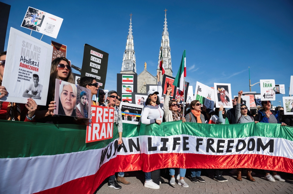Protestors in support of women in Iran hold a banner reading 'Women Life Freedom' during a protest following the death of Mahsa Amini, in Ottawa, Ontario, Canada, on October 29, 2022. REUTERS/Spencer Colby/File Photo