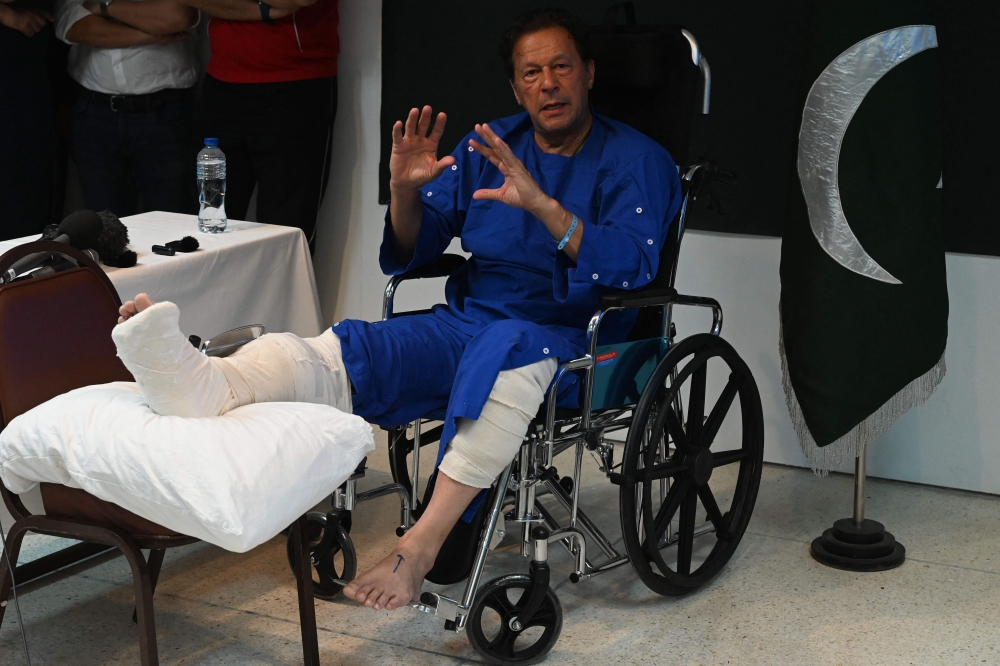 Pakistan's former prime minister Imran Khan talk with media representatives at a hospital in Lahore on November 4, 2022, a day after an assassination attempt on him during his long march near Wazirabad.(AFP/Arif Ali)