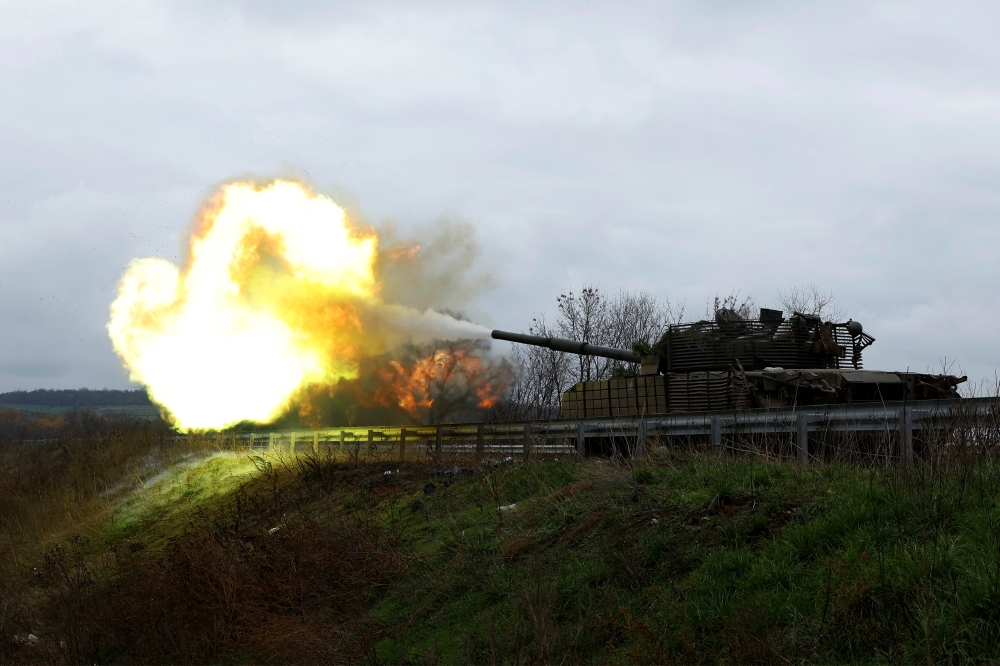Ukrainian soldiers fire a round on the frontline from a T80 tank that was captured from Russians during a battle in Trostyanets in March, as Russia's invasion of Ukraine continues, in the eastern Donbas region of Bakhmut, Ukraine, November 4, 2022. (REUTERS/Clodagh Kilcoyn)