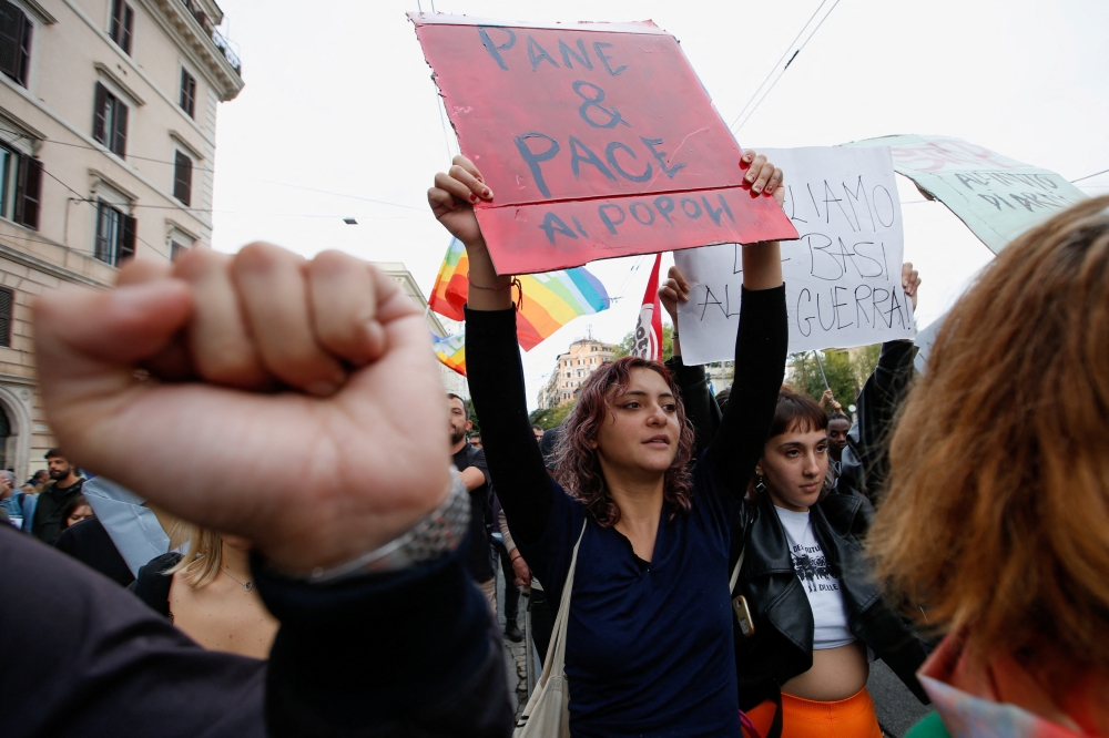 A woman holds a banner reading 