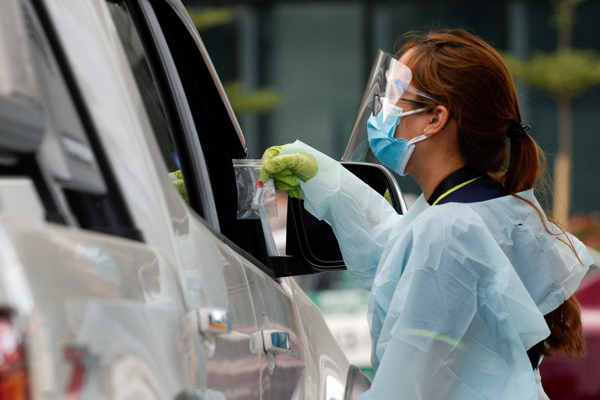 File photo: A health worker collects a saliva sample in a sealed package at a drive-thru coronavirus disease (COVID-19) saliva testing site, in Pasay city, Metro Manila, Philippines, February 3, 2021. )REUTERS/Lisa Marie David)