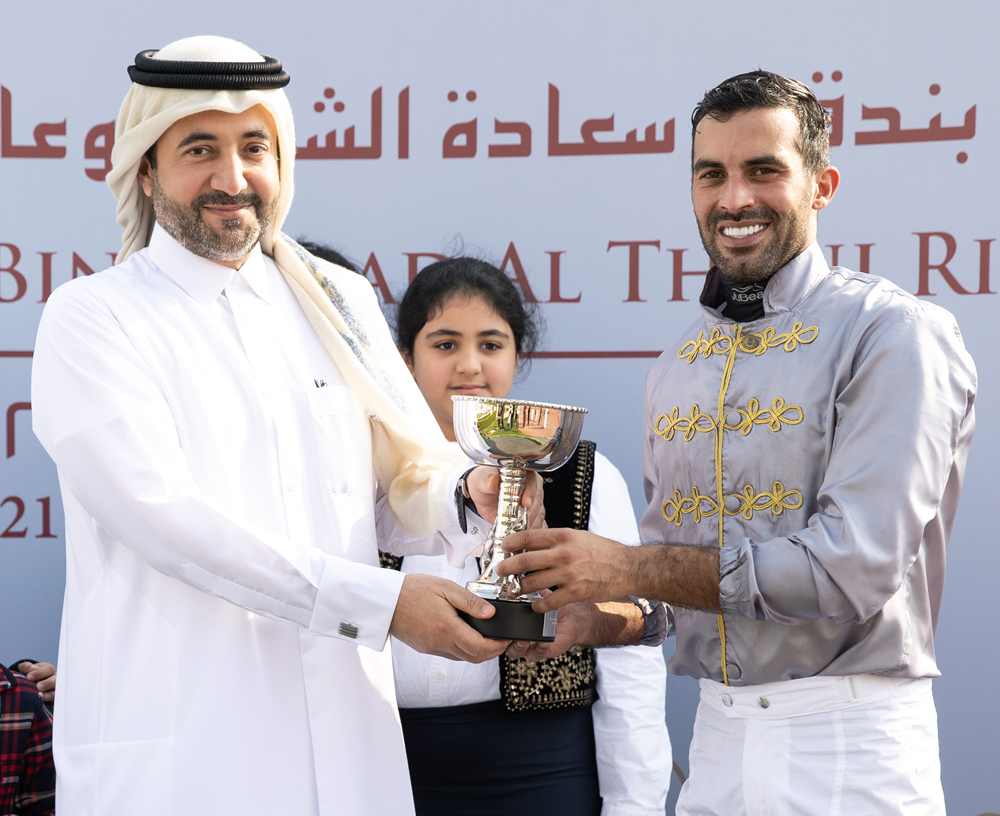 CEO of Qatar Media Corporation (QMC) H E Sheikh Abdulaziz bin Thani Al Thani hands trophy to Faleh Bughanaim, who rode Al Wakrah to win in HE Sheikh Joaan Bin Hamad Al Thani Trophy for Purebred Arabians at Al Rayyan Racecourse yesterday. 