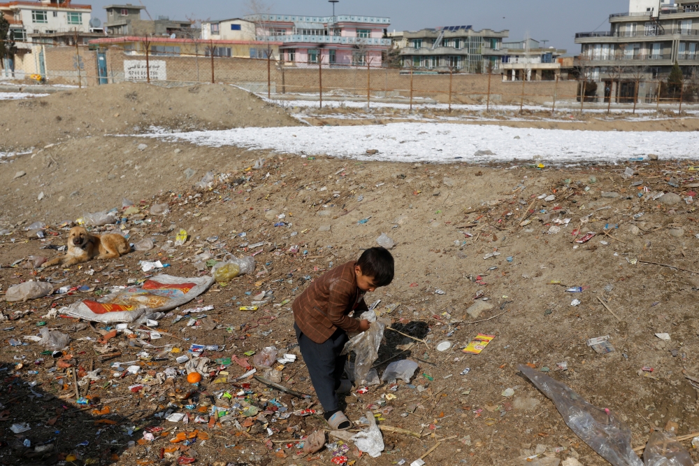 An Afghan child collects plastic to burn for heat in Kabul, Afghanistan, January 26, 2023. REUTERS/Ali Khara