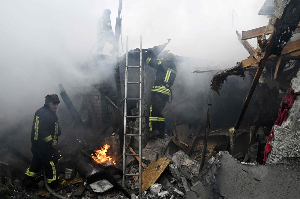 Ukrainian firefighters work in a house in flame following Russian shelling in the city of Kherson, on January 29, 2023, amid the Russian military invasion of Ukraine. (Photo by Genya Savilov / AFP)