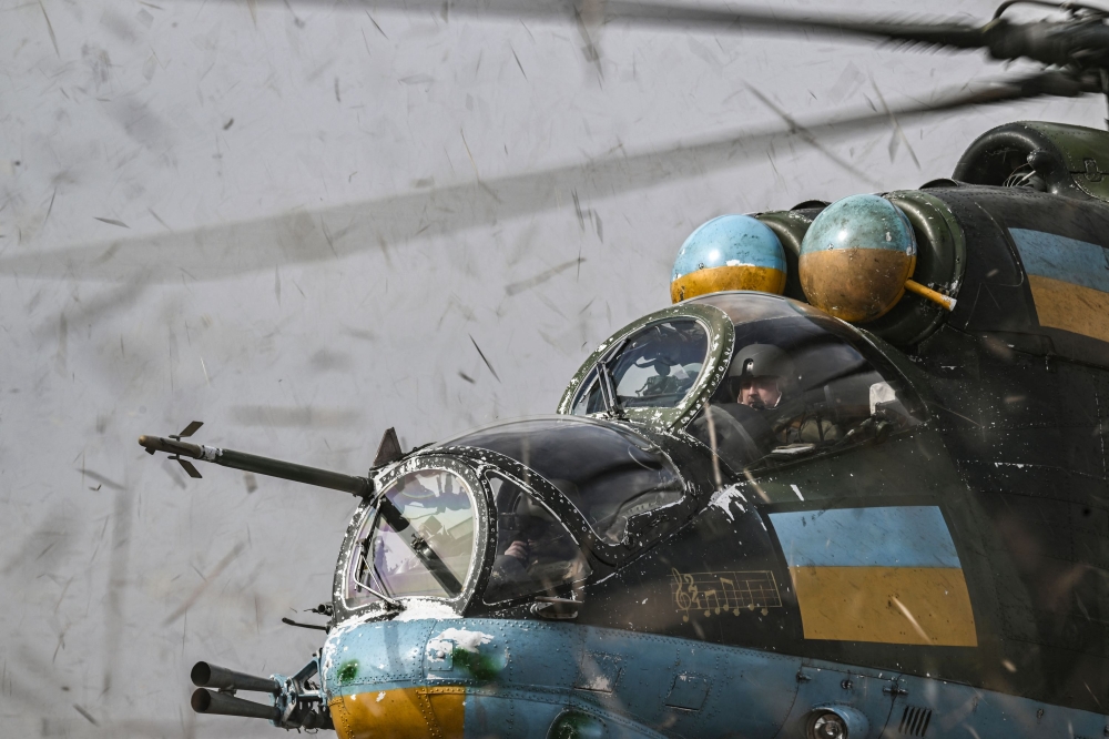 The crew of an Mi-24 fighting helicopter prepares to take off for a mission against Russian targets on March 26, 2023. (Photo by Aris Messinis / AFP)