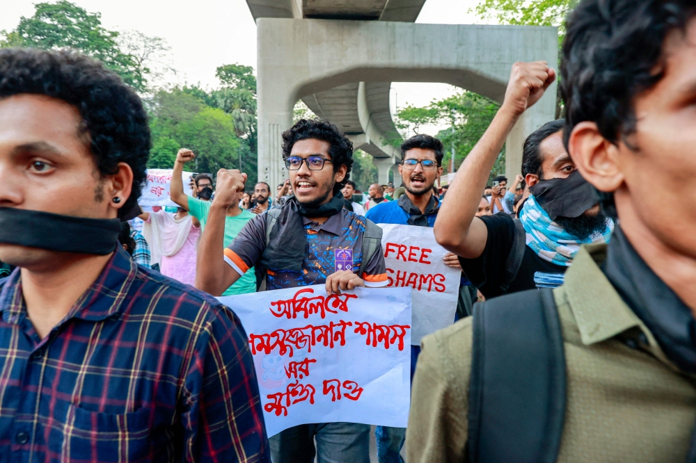 University students hold placards and shout slogans during a protest demanding the immediate release of journalist Shamsuzzaman Shams, who has been charged under the Digital Security Act, at Dhaka University campus in Dhaka March 29, 2023. (Photo by AFP)